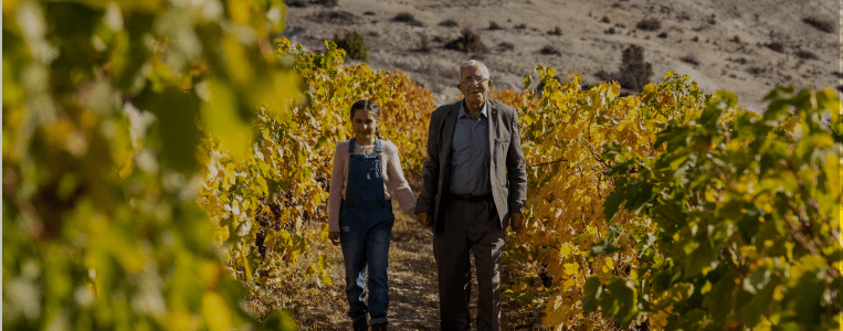 Grandfather and granddaughter walking in vineyard Turkey